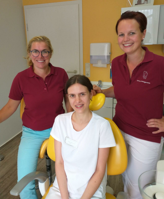 Zahnarztteam im Behandlungsraum mit Auszubildender